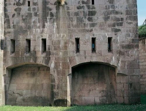 Façade en pierre d’un ouvrage fortifié avec embrasures et arches