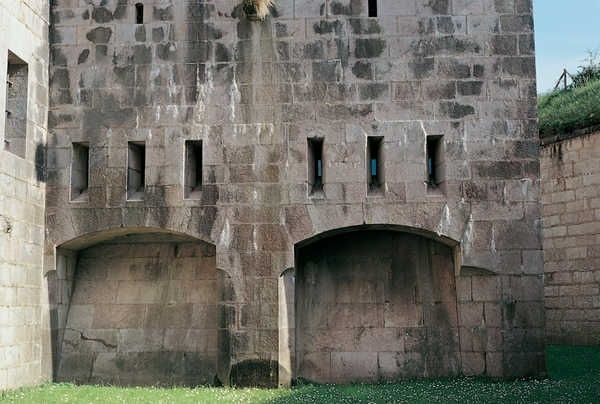 Façade en pierre d’un ouvrage fortifié avec embrasures et arches