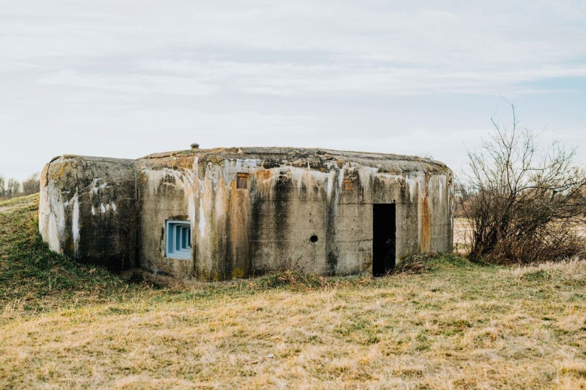 Casemate militaire en béton vieillie, posée dans un pré