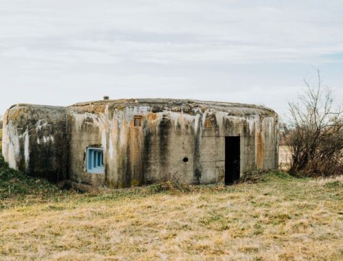 Casemate militaire en béton vieillie, posée dans un pré