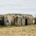 Casemate militaire en béton vieillie, posée dans un pré