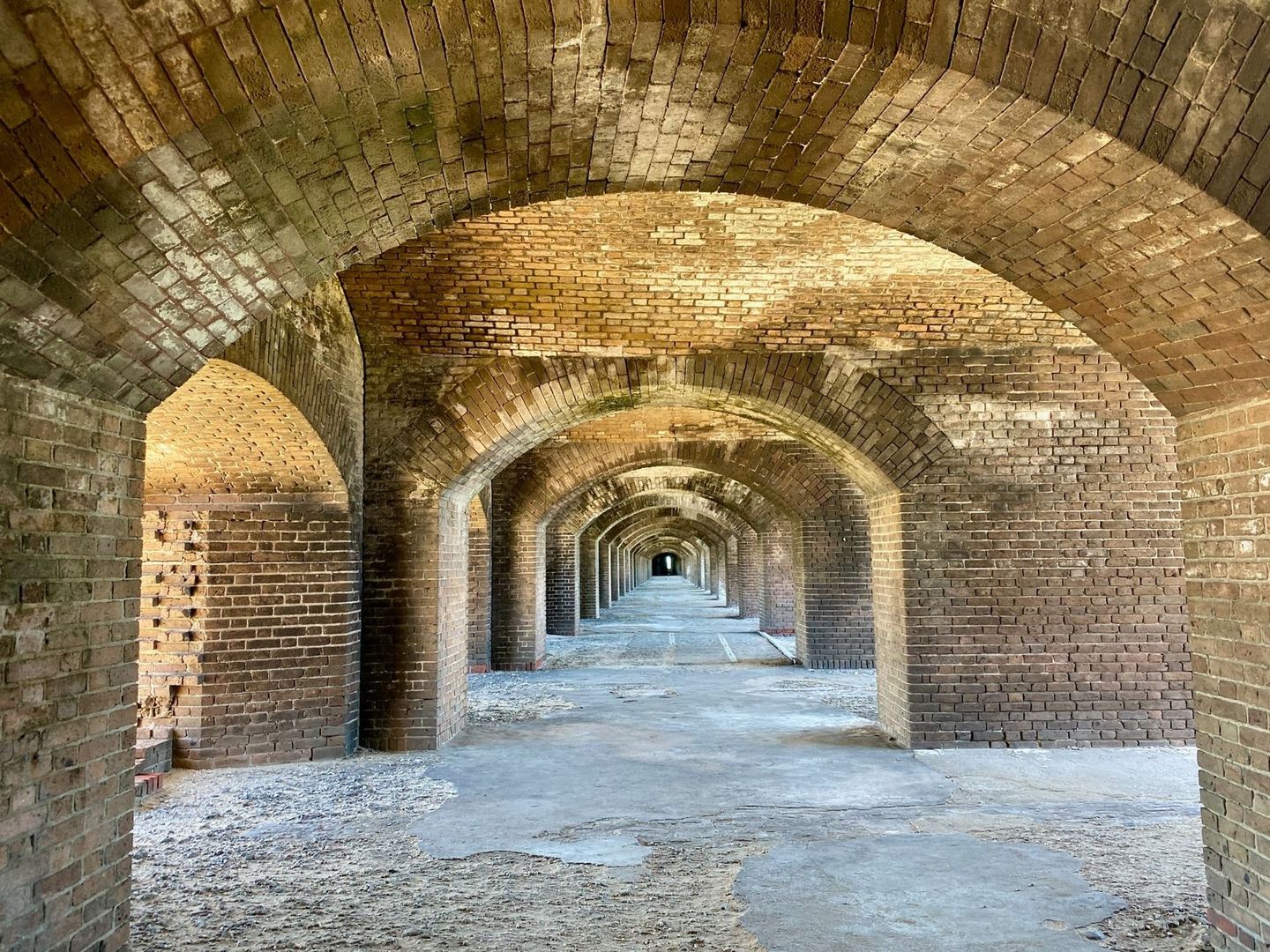 Galerie voûtée en briques dans un fort, avec arches successives